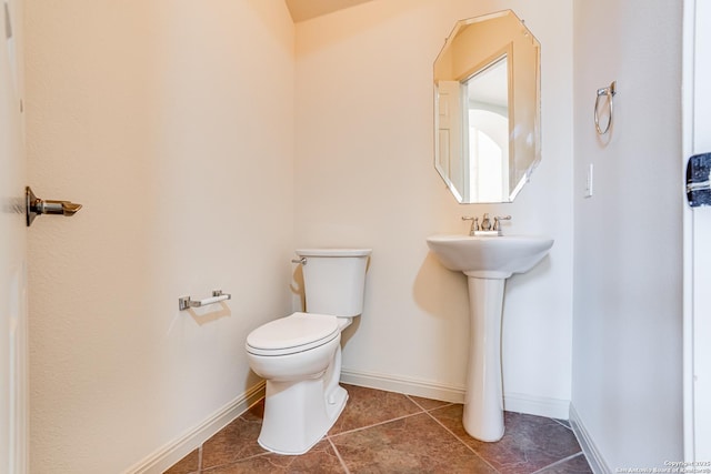 bathroom featuring tile patterned flooring, toilet, and baseboards