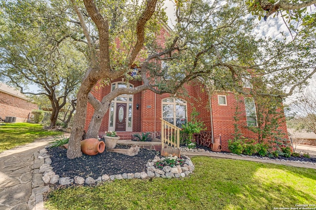 view of front of home with brick siding and a front lawn