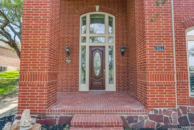 doorway to property featuring brick siding