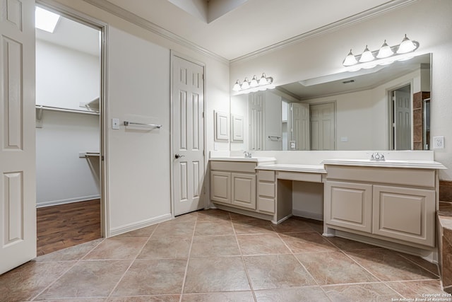 full bath with double vanity, ornamental molding, tile patterned floors, and a sink