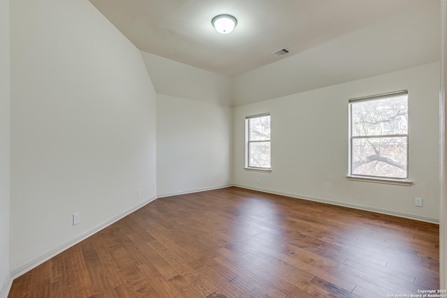 empty room with visible vents, baseboards, and wood finished floors