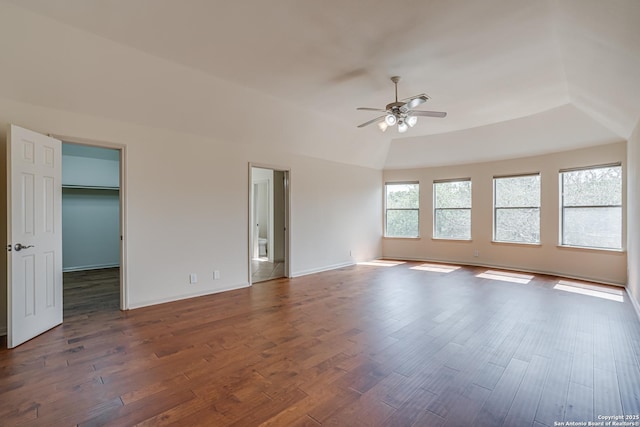 spare room featuring dark wood finished floors, baseboards, lofted ceiling, and ceiling fan