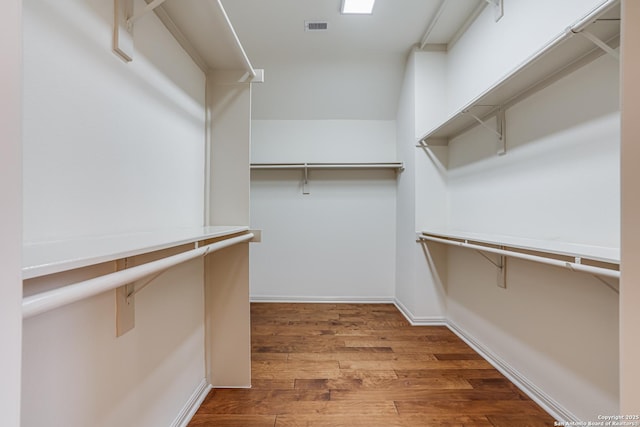 spacious closet featuring wood finished floors and visible vents