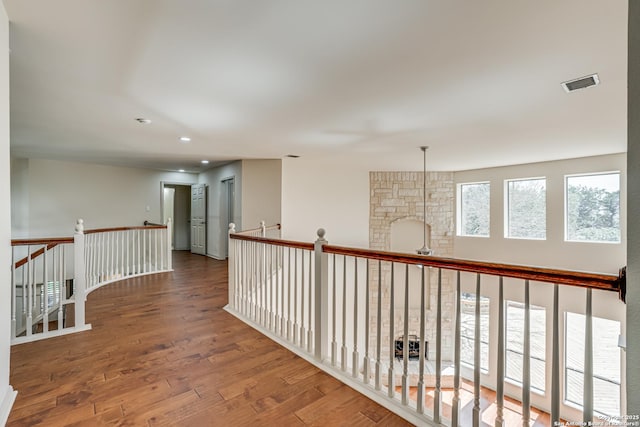 corridor featuring recessed lighting, an upstairs landing, wood finished floors, and visible vents