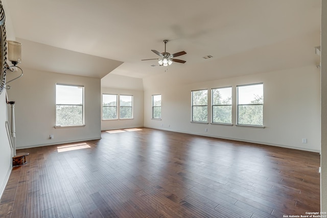 unfurnished room with baseboards, a ceiling fan, and dark wood-style flooring