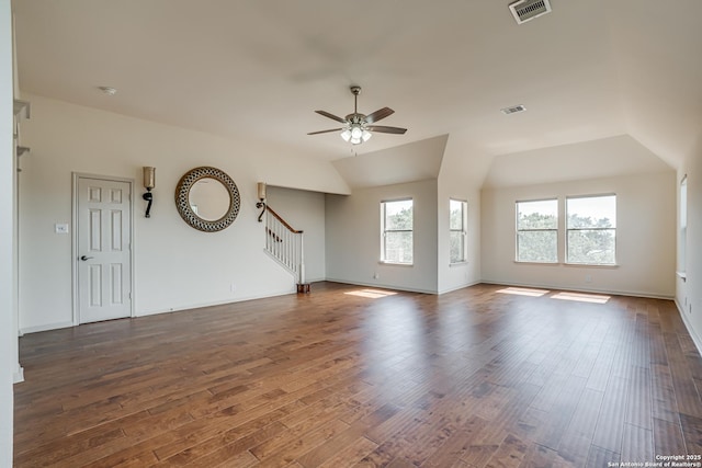 unfurnished living room featuring dark wood finished floors, visible vents, stairs, and a ceiling fan