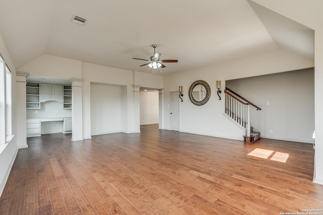 unfurnished living room featuring visible vents, ceiling fan, decorative columns, hardwood / wood-style flooring, and built in study area