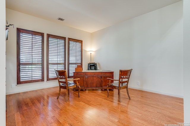 home office featuring visible vents, light wood-type flooring, and baseboards