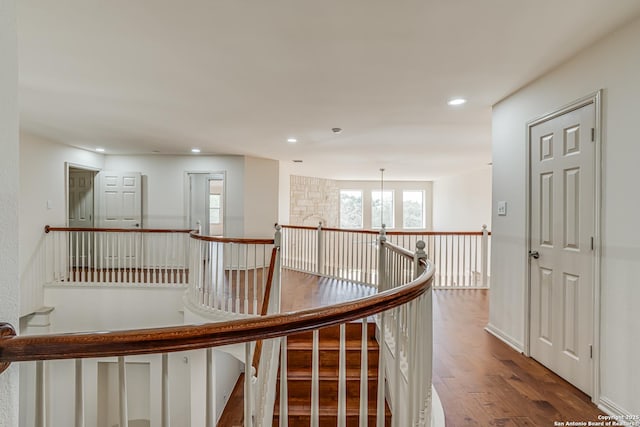 hall featuring recessed lighting, an upstairs landing, and wood finished floors