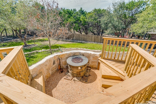 wooden deck with a fire pit and fence