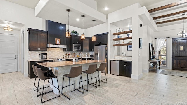 kitchen with a kitchen breakfast bar, tasteful backsplash, appliances with stainless steel finishes, light stone countertops, and extractor fan