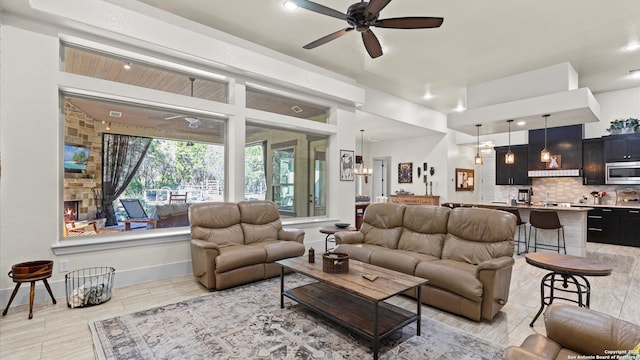 living room featuring baseboards and ceiling fan