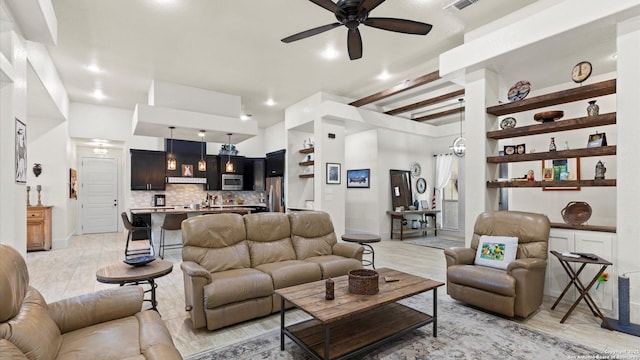 living room featuring visible vents, beamed ceiling, light wood-style floors, and a ceiling fan