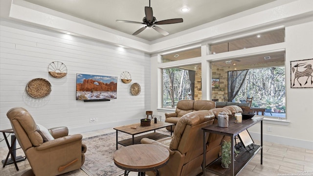 living area with ceiling fan, light wood-type flooring, and baseboards