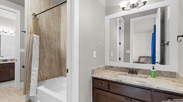 bathroom with vanity, a textured wall, and shower / bath combo