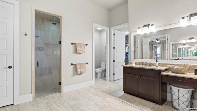 full bath with baseboards, vanity, toilet, and a shower stall