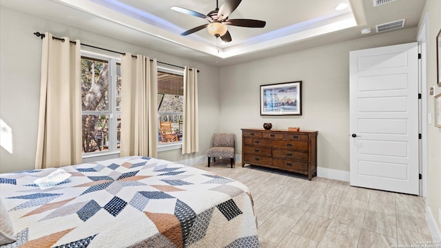 bedroom featuring visible vents, a ceiling fan, a raised ceiling, and baseboards