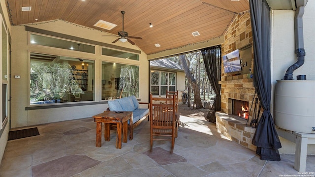 view of patio / terrace with visible vents, an outdoor stone fireplace, and a ceiling fan