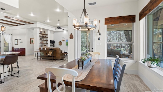 dining area with light wood-style flooring, ceiling fan with notable chandelier, visible vents, and baseboards