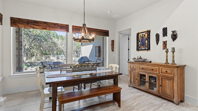 dining room with an inviting chandelier, plenty of natural light, and baseboards