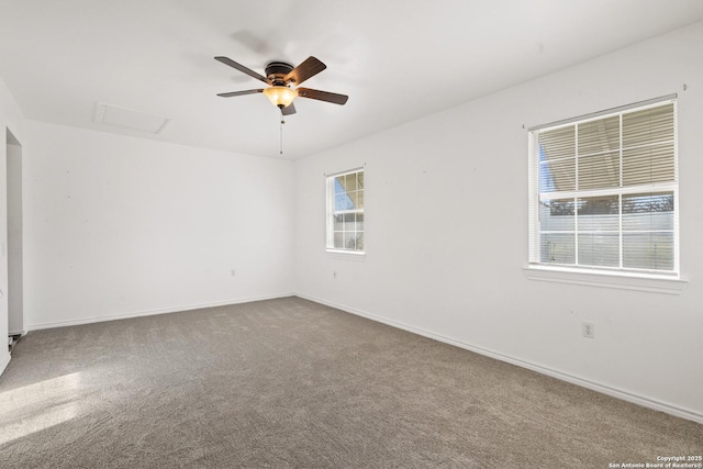 carpeted spare room featuring baseboards and ceiling fan