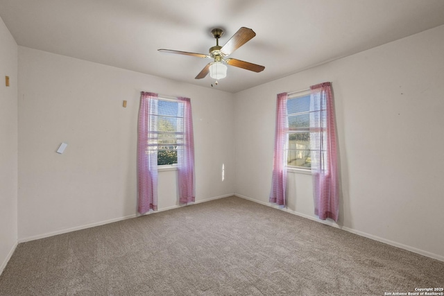 empty room featuring plenty of natural light, baseboards, ceiling fan, and carpet floors