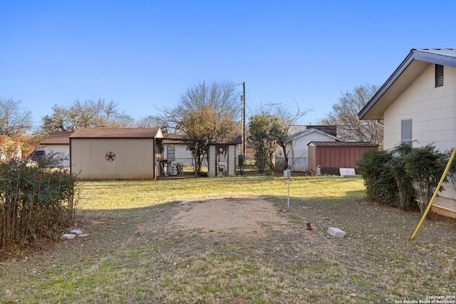 view of yard with a storage unit, an outbuilding, and fence