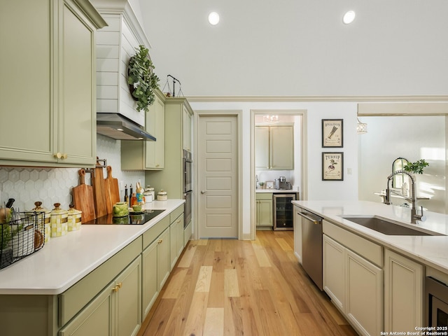 kitchen featuring green cabinetry, a sink, stainless steel appliances, light countertops, and wine cooler