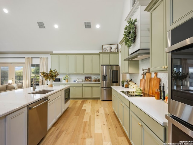 kitchen featuring visible vents, black appliances, a sink, light countertops, and green cabinetry