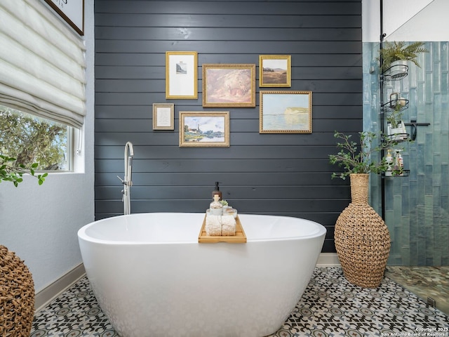 bathroom with baseboards and a freestanding tub