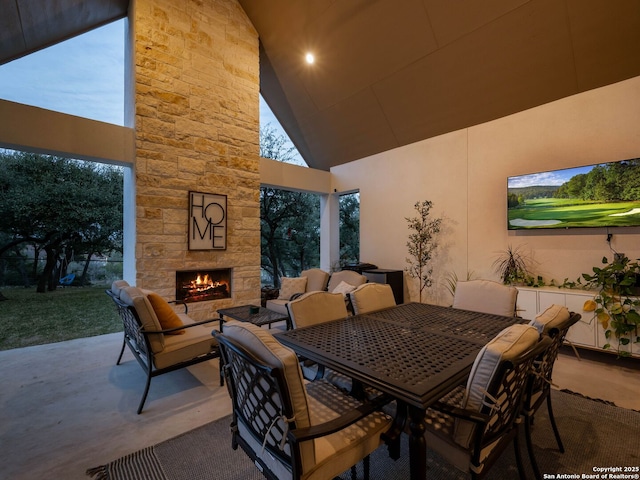 view of patio / terrace with outdoor dining area and an outdoor stone fireplace