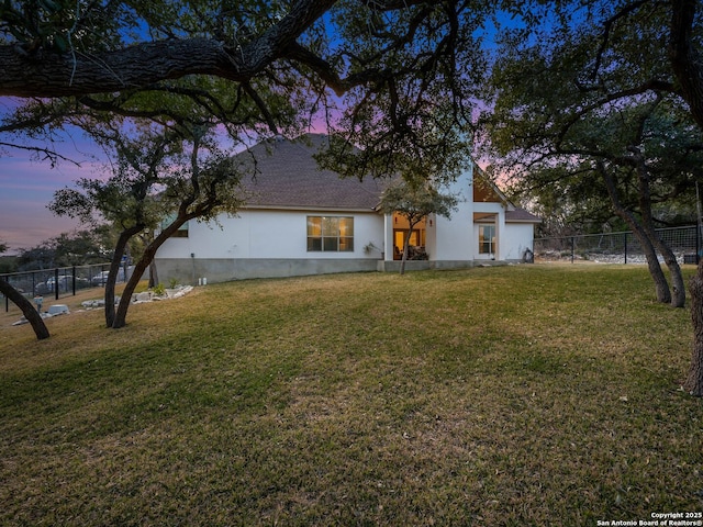 back of property with a fenced backyard and a yard