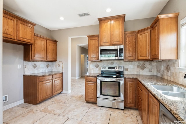 kitchen with a sink, brown cabinets, visible vents, and stainless steel appliances