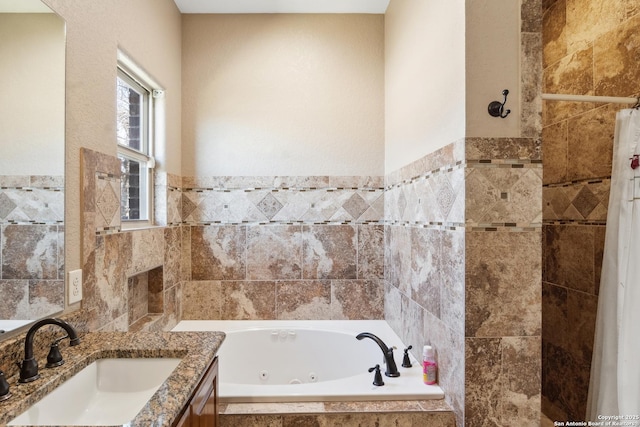 full bathroom featuring vanity, tile walls, and a whirlpool tub