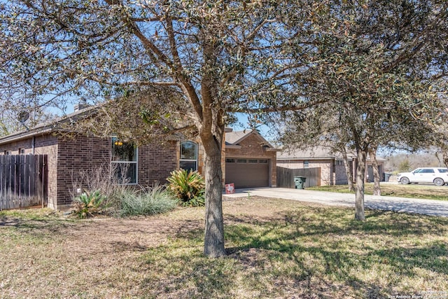 view of front of house with a front yard, fence, concrete driveway, a garage, and brick siding