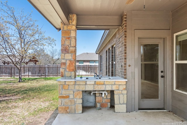 view of patio / terrace featuring a sink and a fenced backyard