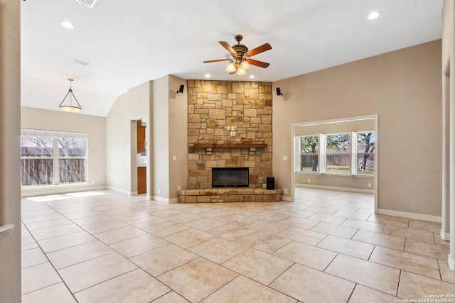 unfurnished living room with a ceiling fan, light tile patterned floors, a fireplace, and a wealth of natural light