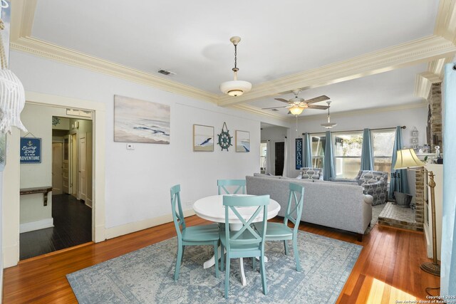 dining area featuring baseboards, crown molding, a ceiling fan, and hardwood / wood-style floors