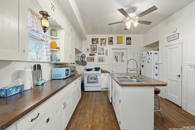 kitchen featuring a sink, white appliances, dark countertops, and dark wood-style floors