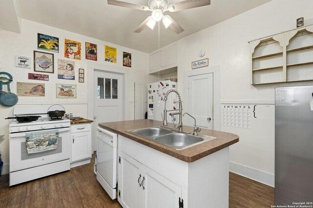 kitchen featuring white appliances, dark wood-style floors, a sink, white cabinets, and dark countertops