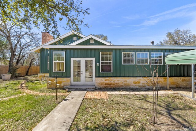 view of front of house featuring french doors, a chimney, board and batten siding, and fence