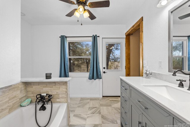 full bathroom featuring a ceiling fan, a bath, and vanity