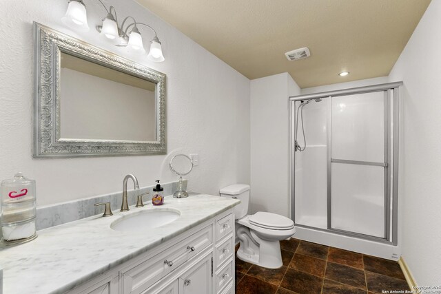 full bath with vanity, visible vents, a shower stall, stone finish floor, and toilet