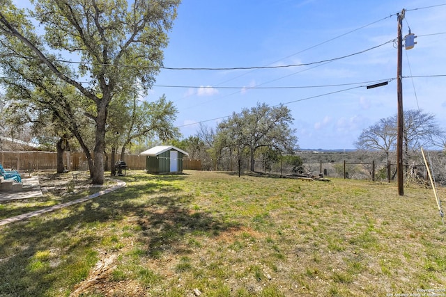 view of yard featuring an outbuilding, a storage unit, and a fenced backyard