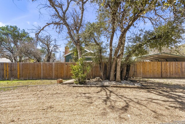 view of yard featuring a detached carport and fence