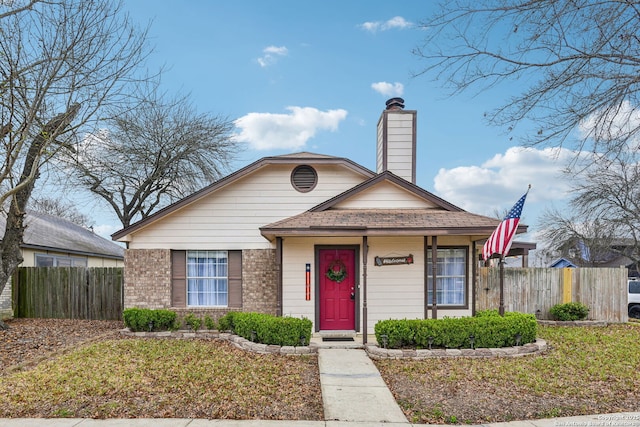 bungalow featuring brick siding, a chimney, and fence