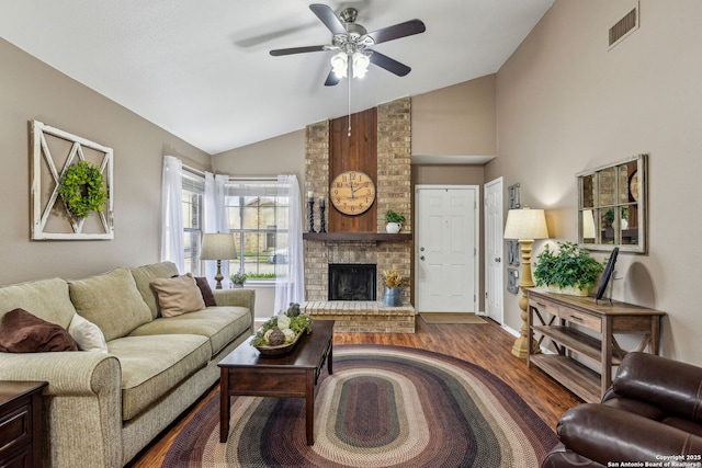 living room with visible vents, a ceiling fan, wood finished floors, a fireplace, and vaulted ceiling