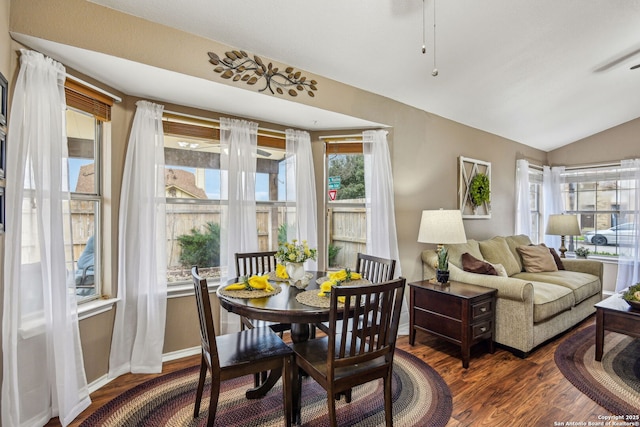 dining area featuring vaulted ceiling, wood finished floors, and baseboards