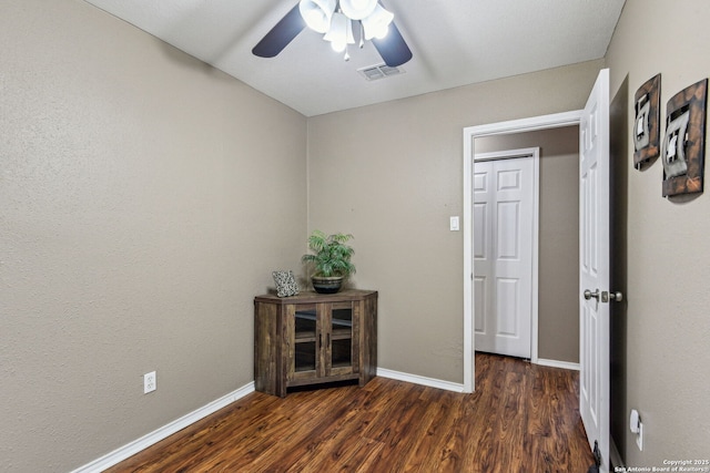 hallway with visible vents, baseboards, and wood finished floors