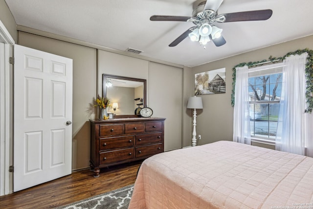 bedroom featuring visible vents, ceiling fan, and dark wood-style flooring